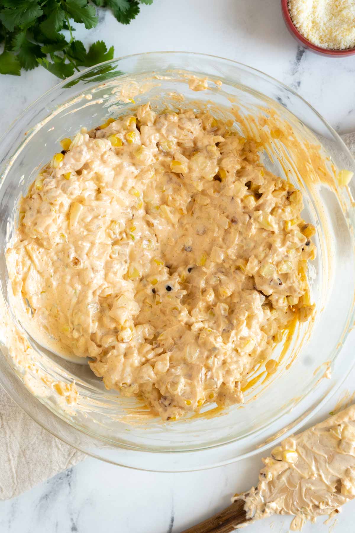 Cream cheese mixture with corn in a mixing bowl.